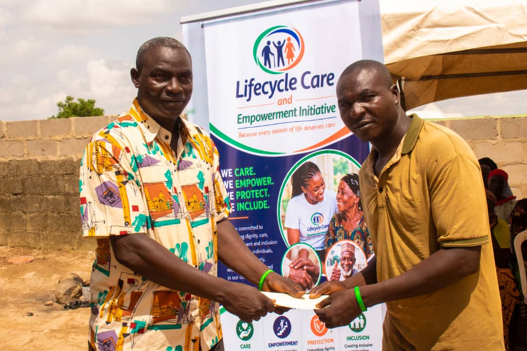 Monthly stipend support presented to a man in front of the Lifecycle Care banner